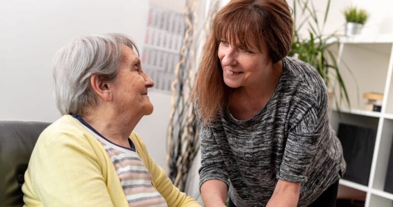 Portrait of old mother supported by her caregiver