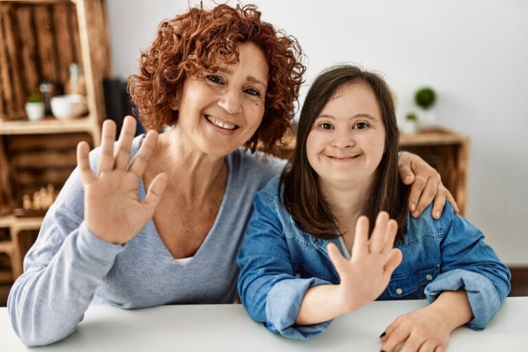 photo of a young adult girl with Down Syndrome and her caregiver