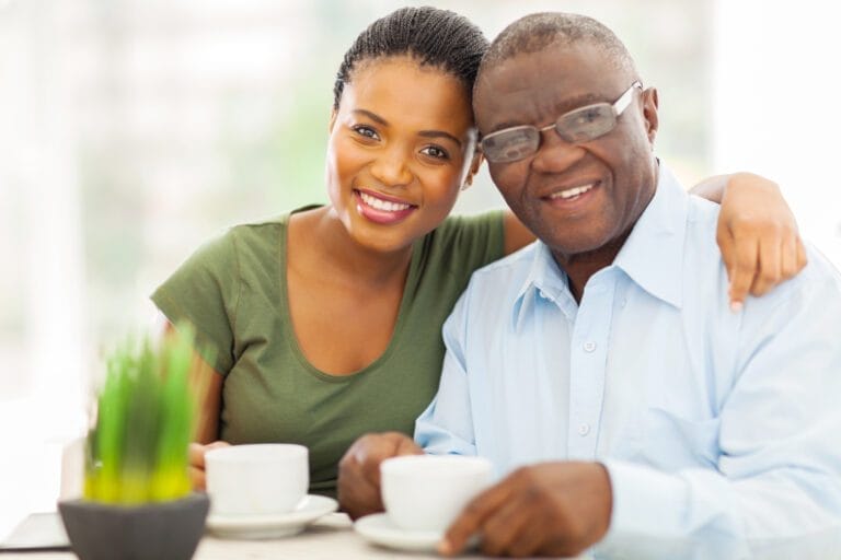 beautiful young adult African American girl and father having coffee at home