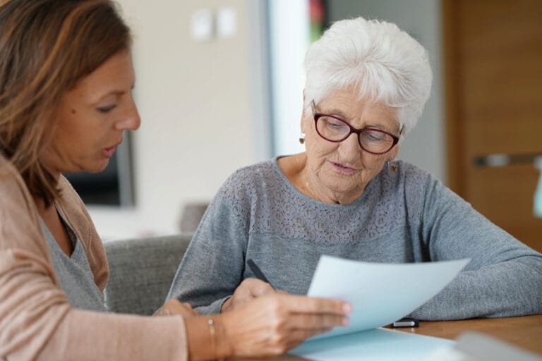 Home assistant helping elderly woman with paper work